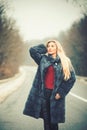 Luxury woman with long blond hair. sexy woman in fur coat. Travel and business trip or hitch hiking Royalty Free Stock Photo