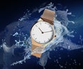 Luxury women`s watch in water splashes demonstrating its waterproof