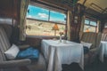 The luxury wooden decoration with comfortable sofas and fancy table lamps of the Perurail Titicaca train.