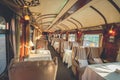 The luxury wooden decoration with comfortable sofas and fancy table lamps of the Perurail Titicaca train.