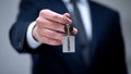 Luxury word on keychain in male hand, VIP hotel room for business client closeup