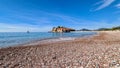 Luxury yacht floating next to idyllic island Sveti Stefan seen from sand beach, Budva Riviera, Adriatic Mediterranean Sea Royalty Free Stock Photo