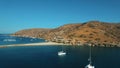 Luxury yachts anchored in meditarranean sea lagoon near the Kolona beach aerial.