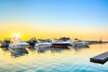 Luxury yachts docked in sea port at sunset. Royalty Free Stock Photo