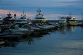 Luxury yachts docked in sea port at sunset. Marine parking of modern motor boats and blue water. Tranquility, relaxation Royalty Free Stock Photo