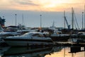 Luxury yachts docked in sea port at sunset. Marine parking of modern motor boats and blue water. Tranquility, relaxation Royalty Free Stock Photo