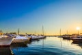 Luxury yachts, sailing and motor boats docked in sea port at sunset. Marine parking of modern motorboats, blue water. Travel. Royalty Free Stock Photo