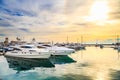 Luxury yachts at sunset. Marine dock of modern motor and sailing boats in sunshine, blue water sea, rainbow with sun.