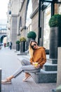 Luxury young woman in fancy clothes having fun on the street with coffe to go in hand. Stylish happy young woman in sunglasses