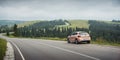 Beige colored SEAT hatchback parked on the side of the mountain road. Royalty Free Stock Photo