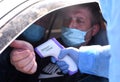 Lviv, Ukraine - April 10, 2020: Medical worker checks temperature of a driver on a checkpoint on the entrance to Lviv region.