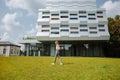 LVIV, UKRAINE - AUGUST  25, 2018 : Beautiful hipster girl is standing near the modern architecture building. Stylish business Royalty Free Stock Photo