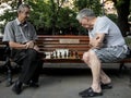 LVIV, UKRAINE - AUGUST 19, 2015: Old men playing chess on a bench in a park of Lviv Royalty Free Stock Photo