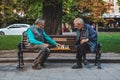 Lviv, Ukraine - August 3, 2019 - seniors playing chess at city bench park