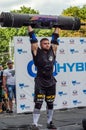 LVIV, UKRAINE - AUGUST 2017: A strong athlete picks up a huge heavy pack of barbell over his head in front of admiring spectators
