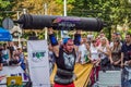 LVIV, UKRAINE - AUGUST 2017: A strong athlete picks up a huge heavy pack of barbell over his head in front of admiring spectators