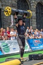 LVIV, UKRAINE - AUGUST 2017: A strong athlete picks up a huge heavy pack of barbell over his head in front of admiring spectators