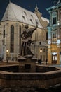 Lviv, Ukraine - December 8, 2021: Sculpture of Neptune silhouette on the Market square on evening. Sculpture Covered In Snow