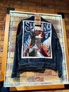 Lviv, Ukraine - February 16, 2025: Customized denim jacket with graphic back design displayed on a rustic brick wall