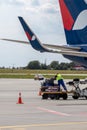 Airport staff load a plane with luggage