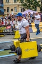 LVIV, UKRAINE - JULY 2016: Mighty strong athlete bodybuilder strongman carries heavy iron suitcases on the street in front of