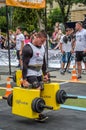 LVIV, UKRAINE - JULY 2016: Mighty strong athlete bodybuilder strongman carries heavy iron suitcases on the street in front of