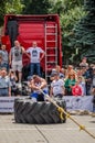 LVIV, UKRAINE - JULY 2016: Strong athlete strongman pulling a rope truck sitting with a partner is not huge tires Royalty Free Stock Photo