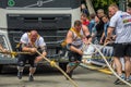 LVIV, UKRAINE - JULY 2016: Two strong athlete bodybuilder strongman pulling with ropes two huge truck in front of enthusiastic Royalty Free Stock Photo