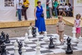 LVIV, UKRAINE - JUNE 2016: Young children, the future grandmasters play on a chess board chess exercising outdoors huge figures