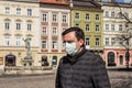 LVIV,UKRAINE, 22 March 2020: handsome young European man on the empty street wearing disposable protective face mask during