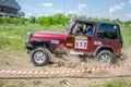 LVIV, UKRAINE - MAY 2016: Huge tuned car Jeep SUV driving on a dirt road rally, raising a cloud of dust behind, among the Royalty Free Stock Photo