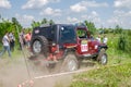 LVIV, UKRAINE - MAY 2016: Huge tuned car Jeep SUV driving on a dirt road rally, raising a cloud of dust behind, among the Royalty Free Stock Photo