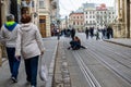 A team of photographers takes pictures of a romantic young man and a young woman hugging and kissing on the ancient street of the