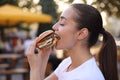 Lviv, Ukraine - September 26, 2023: Woman eating McDonald\'s burger outdoors