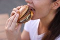 Lviv, Ukraine - September 26, 2023: Woman eating McDonald\'s burger outdoors, closeup