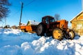 Lyashki, Russia - February 23, 2018: Old tractor removes snow in winter on the street of a traditional Russian village