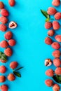 Lychee frame. Exotic asian fruits on blue background top-down copy space Royalty Free Stock Photo