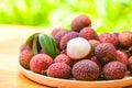 Lychee frui with green leaf on wooden plate background , fresh ripe lychee peeled from lychee tree at tropical fruit Thailand in