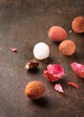 Lychee fruits, Fresh lychee and peeled showing the red skin and white flesh on a rusty dark background, top view, copy space Royalty Free Stock Photo