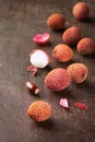 Lychee fruits, Fresh lychee and peeled showing the red skin and white flesh on a rusty dark background, top view, copy space Royalty Free Stock Photo