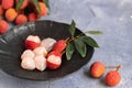 Lychee with leaves on gray background. Tropical fruit Royalty Free Stock Photo