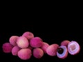 Lychee- small rounded fruit with sweet white scented flesh, a large central stone, and thin rough skin- on black background.