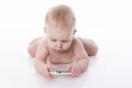 Lying baby is learning to deal with a phone Royalty Free Stock Photo