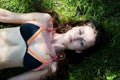 Lying on background of green grass. Woman relaxing outdoors. sexy girl in swimsuit. woman in grass bed. summer nature freedom. Royalty Free Stock Photo