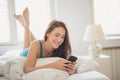 Lying on the bed and typing on the phone Royalty Free Stock Photo