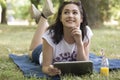 Lying on the grass and holding a tablet Royalty Free Stock Photo