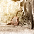 a lying hiking backpack lying next to a bicycle on the ground on a forest path in a coniferous thicket Royalty Free Stock Photo