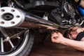 Lying Man Fixing his Motorbike Using Wrench Tool Royalty Free Stock Photo