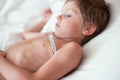 Lying sick little child with thermometer in the armpit Royalty Free Stock Photo