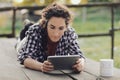 Woman uses tablet in countryside with cat